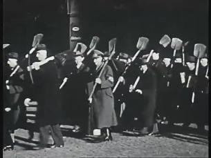 Männer des Volkssturms marschieren mit Spaten